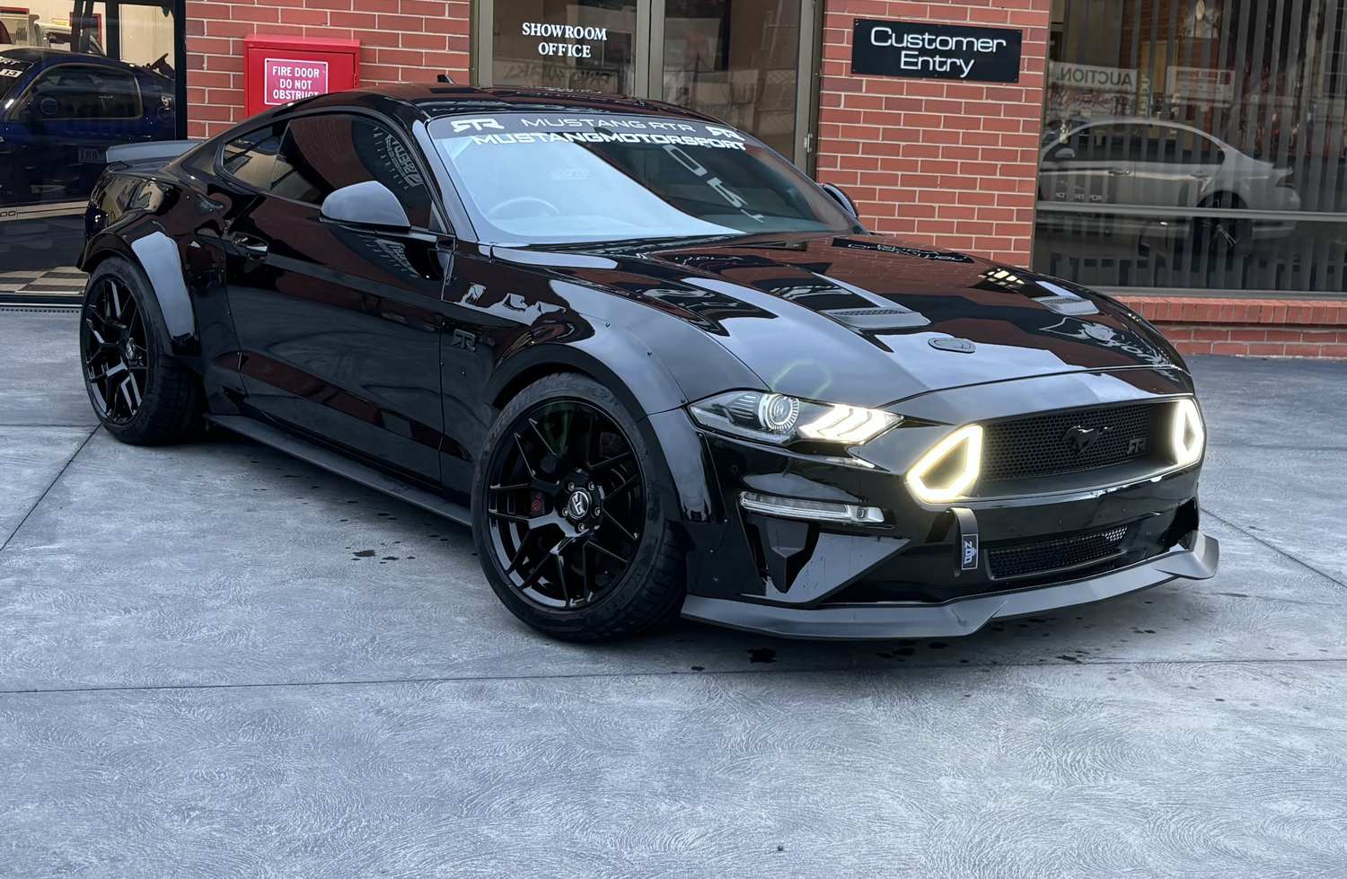 Black Ford Mustang RTR with a deep mirror gloss finish after a cut and polish